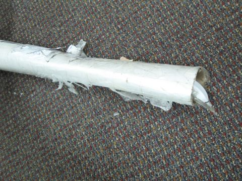 1971 Ford Ranchero - Exhaust pipe, partially unwrapped, lies on a carpeted surface.