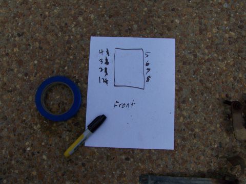 1992 Ford Bronco - Photograph of a hand-drawn sheet of paper noting cylinder numbering with tape and a marker, resting on pavement.