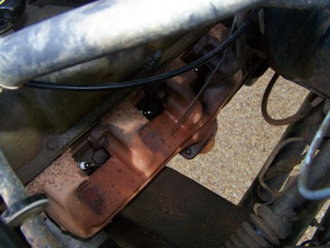 1992 Ford Bronco - Close-up view of an exhaust manifold and spark plug, likely from an older vehicle's engine bay.