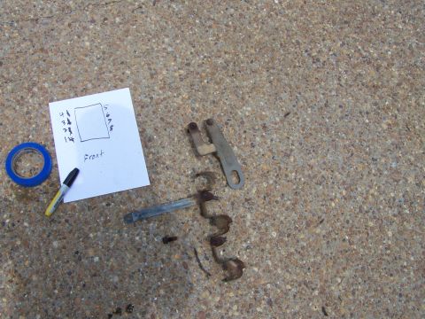 1992 Ford Bronco - Vehicle parts are shown on a concrete surface next to a handwritten diagram and blue tape.
