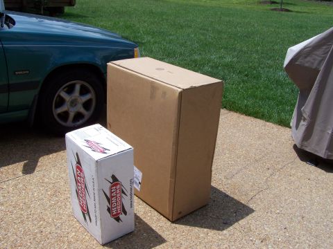 1992 Ford Bronco - A green Volvo is parked next to two large cardboard boxes on a concrete driveway.