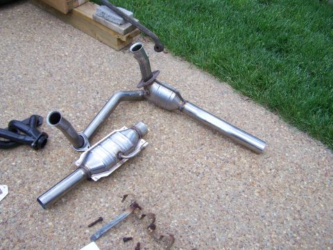1992 Ford Bronco - Exhaust system components, including catalytic converters and pipes, are displayed on a paved surface.