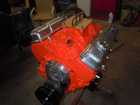 1973 Chevrolet Camaro - V8 engine block painted orange with chrome valve covers and a front pulley assembly.