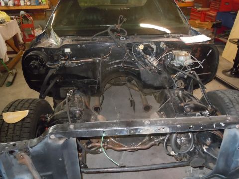 1973 Chevrolet Camaro - The front end of a disassembled car, revealing the engine bay and suspension components.