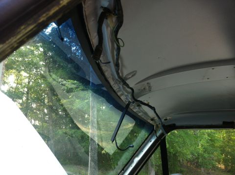 1996 Ford Bronco - Exposed wiring and trim around the overhead console of a vehicle, seen from the interior looking outwards.