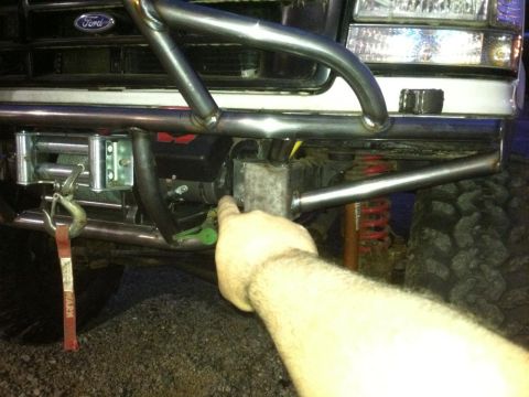 1996 Ford Bronco - Custom front bumper assembly with winch, tow hook, and a hand pointing to a component.