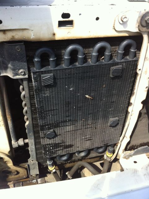 1996 Ford Bronco - Auxiliary transmission or engine oil cooler with black tube-and-fin construction mounted in front of the radiator, secured by four push-thr…