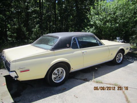 1968 Mercury Cougar - This 1968 Mercury Cougar coupe is seen from the rear quarter angle, a yellow body and a black vinyl roof.