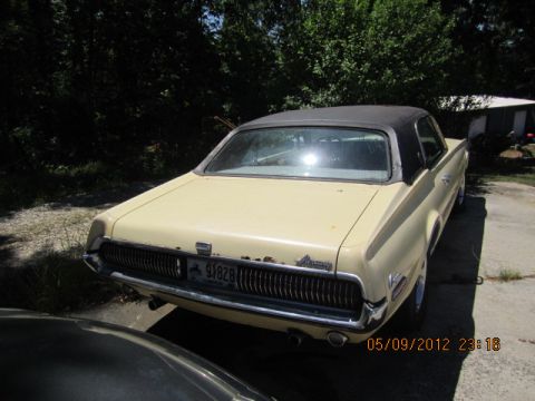 1968 Mercury Cougar - Rear view of a 1968 Mercury Cougar with a black vinyl top and light yellow paint.