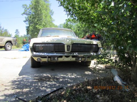 1968 Mercury Cougar - A 1967 Mercury Cougar is seen from the front, parked in a driveway with trees and another vehicle in the background.