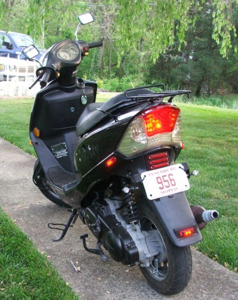 2008 Yamaha Zuma - Rear view of a black scooter parked on a sidewalk with a license plate that reads 956 MOPED.