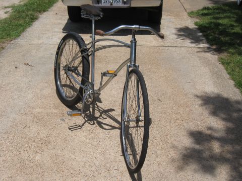 1994 Ford Bronco - A bicycle is parked on a concrete driveway, partially obscuring a vehicle's rear bumper and license plate.