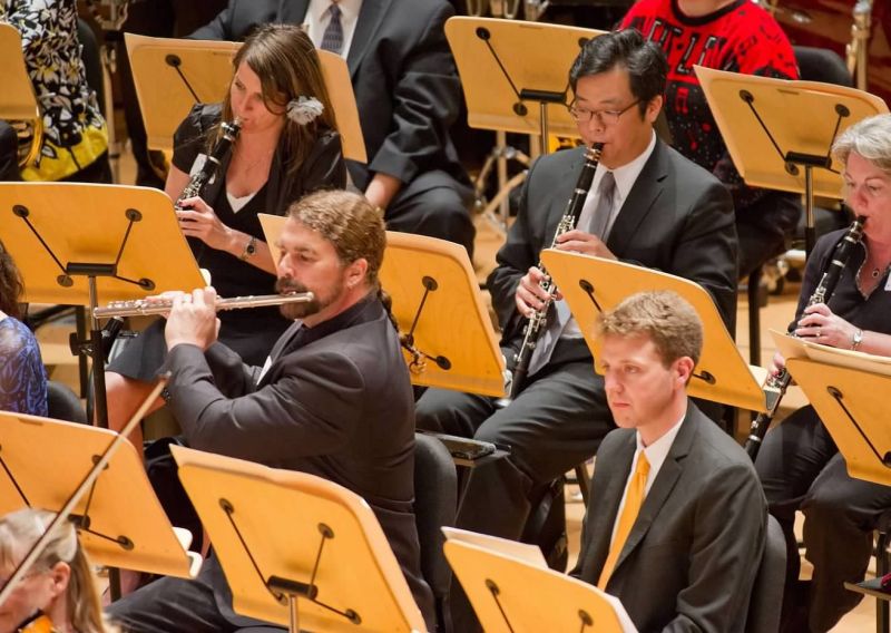 Musicians in an orchestra playing clarinets and a flute