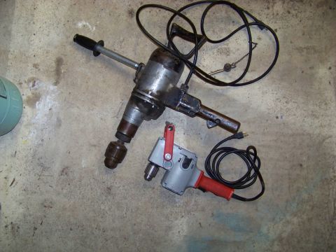 1994 Ford F-150 - A vintage heavy-duty drill and a smaller modern drill are displayed on a concrete surface.