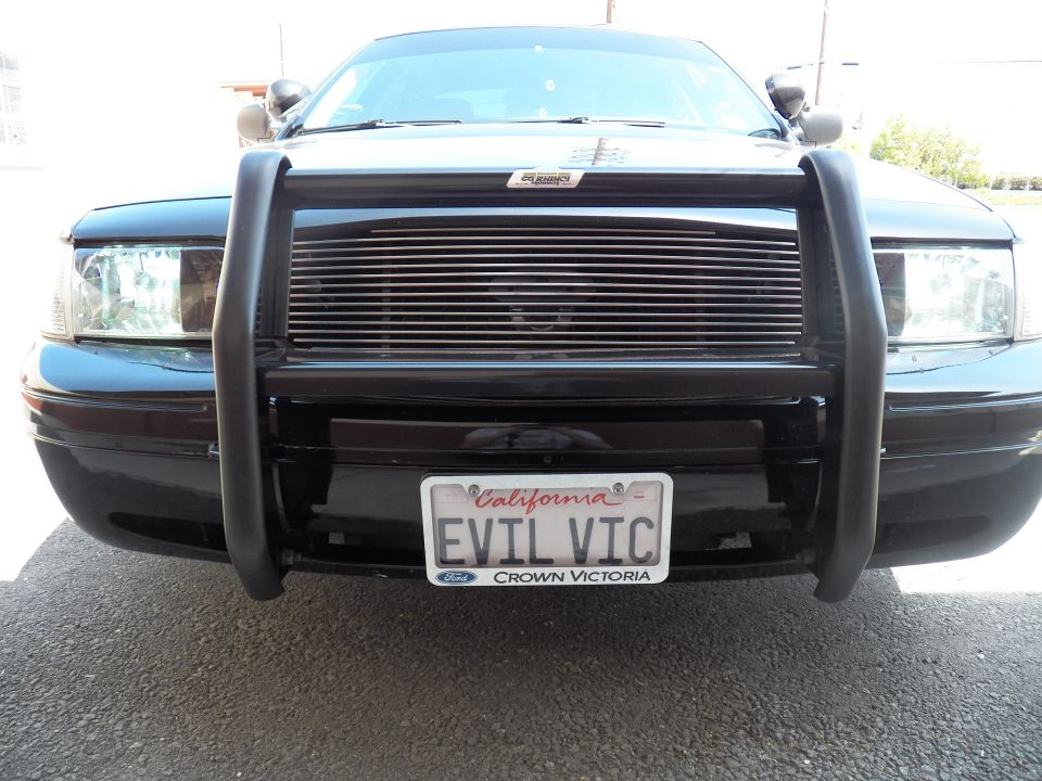 Front of black Ford Crown Victoria with push bar and EVIL VIC California plate