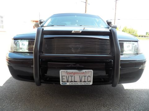 2003 Ford Crown Victoria - Front view of dark Ford sedan fitted with push bumper, billet grille and EVIL VIC tag