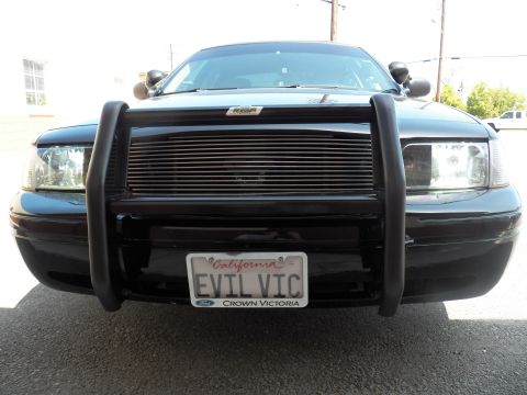 2003 Ford Crown Victoria - Front of black Ford sedan with push bumper and billet grille, EVIL VIC plate centered