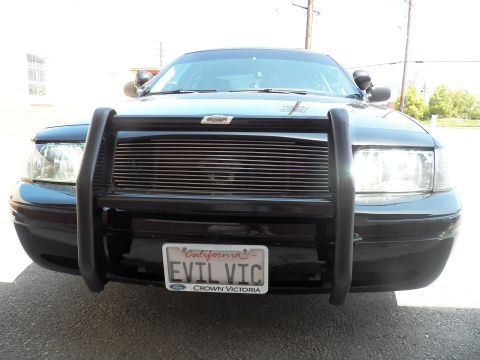 2003 Ford Crown Victoria - Front of black Ford sedan with tubular push bumper, billet grille and EVIL VIC plate centered