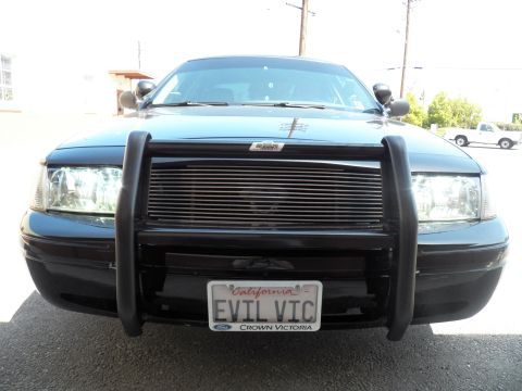 2003 Ford Crown Victoria - Front view of dark Ford sedan with brush guard and billet grille, EVIL VIC California tag
