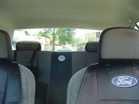1999 Ford Crown Victoria - Rear interior view of a 1999 Ford Crown Victoria, with seat covers and a view of the outside.