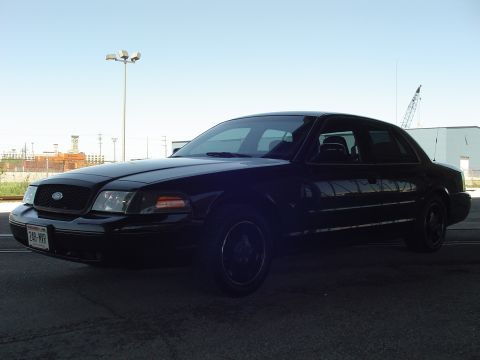 1999 Ford Crown Victoria - This black 1998 Ford Crown Victoria is captured in a 3/4 front view, showing its distinctive body style.