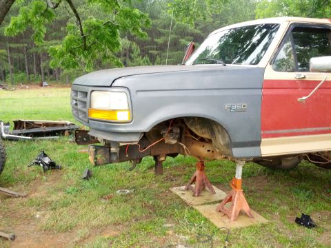 1987 Ford Bronco - This Ford F-350 truck appears to be undergoing repairs or modifications, with its front end disassembled and supported by jack stands.