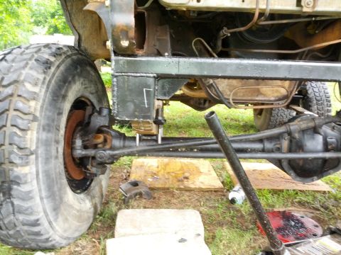 1987 Ford Bronco - Close-up view of a vehicle's undercarriage, showing suspension and frame modifications.