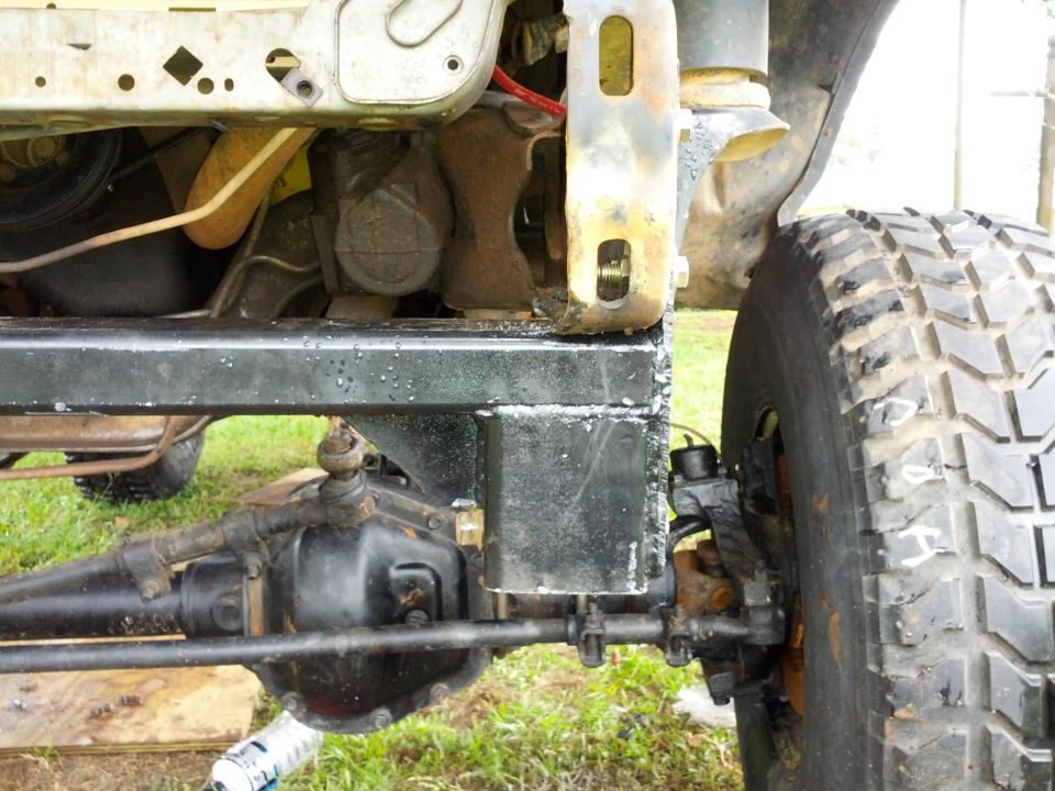 Off-road vehicle chassis with large tire, visible suspension components, and frame modifications