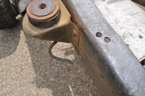 1986 Ford Bronco - Close-up of a vehicle's frame and suspension component, showing a rubber isolator and rusty metal.