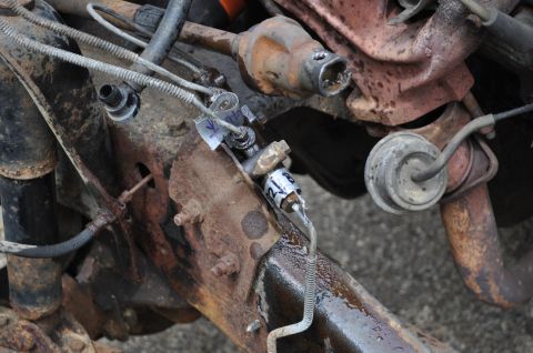 1986 Ford Bronco - This image shows a section of a vehicle's frame with various mechanical components attached, including brake lines and part of the engine.