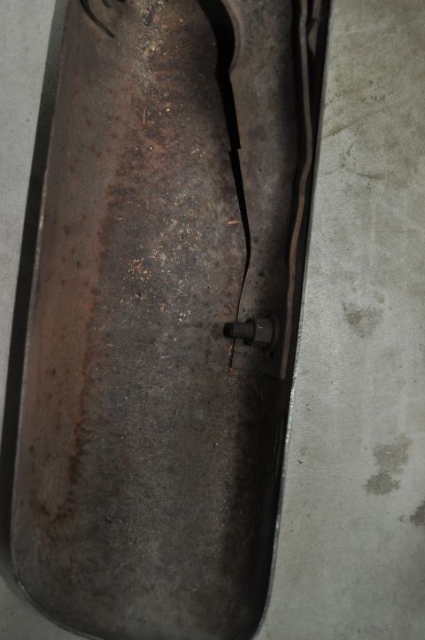 1986 Ford Bronco - A heavily rusted exhaust pipe exhibits a large crack and a protruding bolt, indicating severe wear and tear.