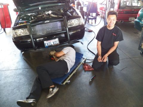2003 Ford Crown Victoria - Front-mount intercooler and piping visible under the open hood of the EVIL VIC Crown Victoria during shop work