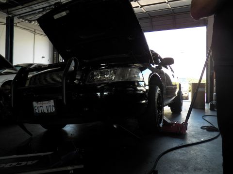 2003 Ford Crown Victoria - Backlit front end of the EVIL VIC Crown Victoria on a jack, brush guard dark against open bay door