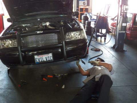 2003 Ford Crown Victoria - Worker reaches under the EVIL VIC Crown Vic front bumper, intercooler and turbo piping under the raised hood