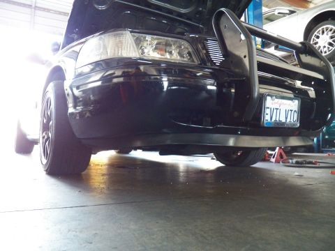 2003 Ford Crown Victoria - Wide low view of the EVIL VIC Crown Victoria front fender, wheel and push bar in the garage bay