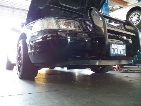 2003 Ford Crown Victoria - Close low-angle of the EVIL VIC Crown Vic headlight and brush bar, another car visible on the lift behind
