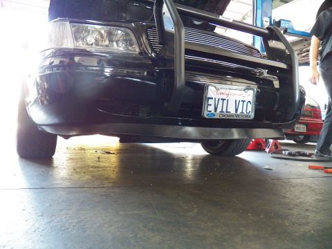 2003 Ford Crown Victoria - EVIL VIC plate with Ford and Crown Victoria lettering on the brush-barred front end, tech standing at right
