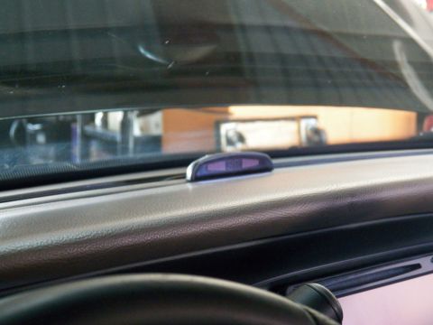 2003 Ford Crown Victoria - View across a textured dash to the windshield, with a small purple display mounted on top.