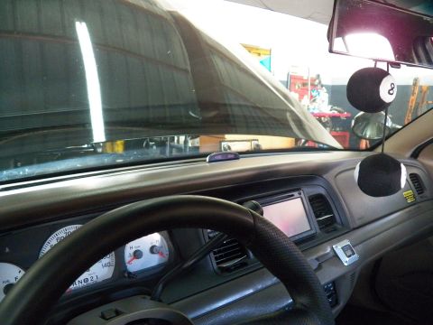 2003 Ford Crown Victoria - Driver-view interior showing gauges, an aftermarket touchscreen head unit and 8-ball dice hung from the mirror.