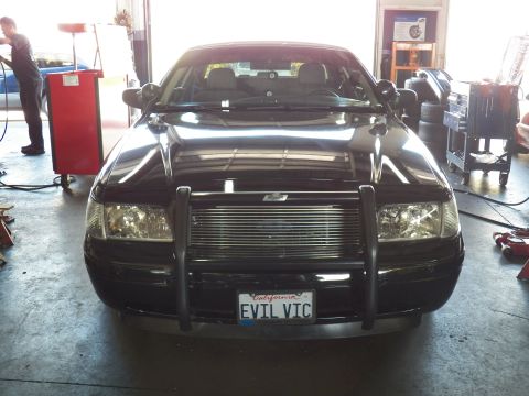 2003 Ford Crown Victoria - Head-on shot of a black sedan with tubular brush guard and California EVIL VIC license plate.
