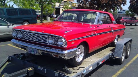 1964 Ford Fairlane - A red 1964 Ford Fairlane coupe is transported on a trailer.