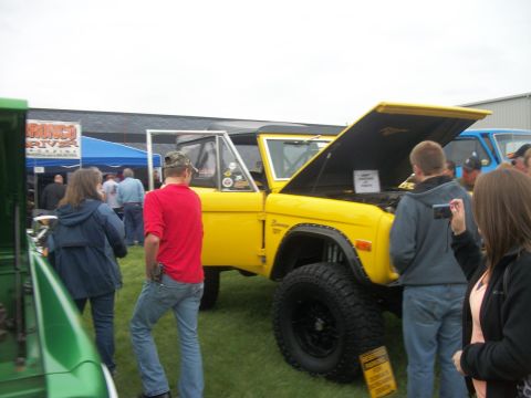 1996 Ford Bronco - Yellow Ford Bronco, likely a 1978 model, displayed with its hood open at an outdoor event.
