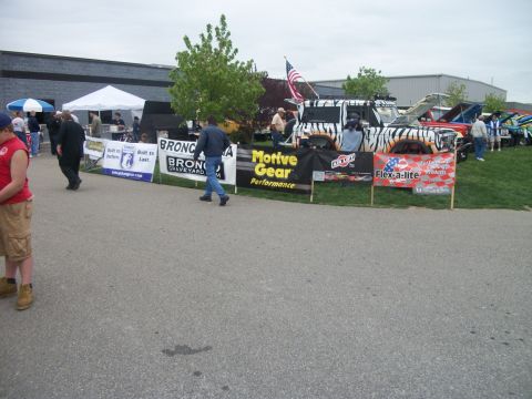 1996 Ford Bronco - Multiple vehicles are displayed on a grassy area with banners in front.