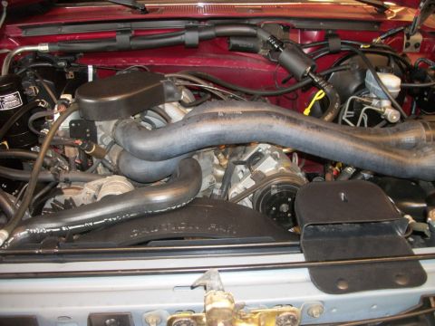 1996 Ford Bronco - Close-up view of the engine compartment, showing various hoses, belts, and the fan.