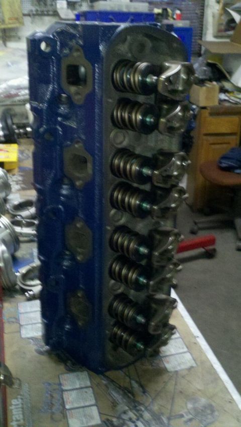 1982 Ford Bronco - A close-up view of a blue painted engine cylinder head, showing its internal valve components.