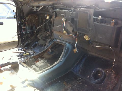 1989 Ford Bronco - The interior of a vehicle is shown with the dashboard and center console removed, exposing wiring and mechanical components.