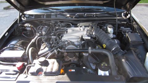2003 Mercury Marauder - The engine bay of a 2003 Mercury Marauder is visible with the hood raised, revealing the V8 engine and associated parts.