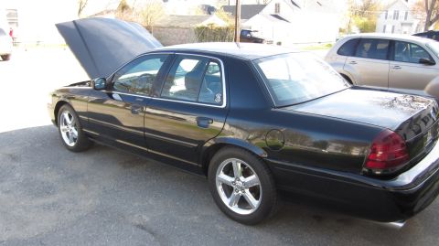 2003 Mercury Marauder - A black sedan is parked outdoors with its hood up, showing a glimpse of the engine bay.