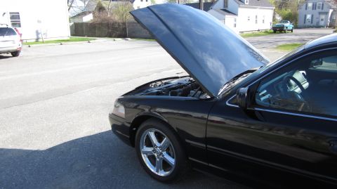 2003 Mercury Marauder - A black 2003 Mercury Marauder is parked with its hood open, showing the engine compartment.