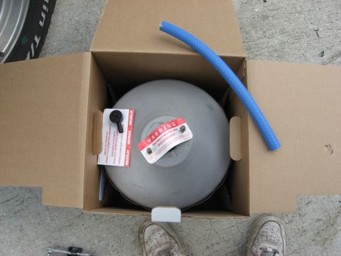 1994 Ford Bronco - A new brake booster and hose are shown inside their shipping box, ready for installation.